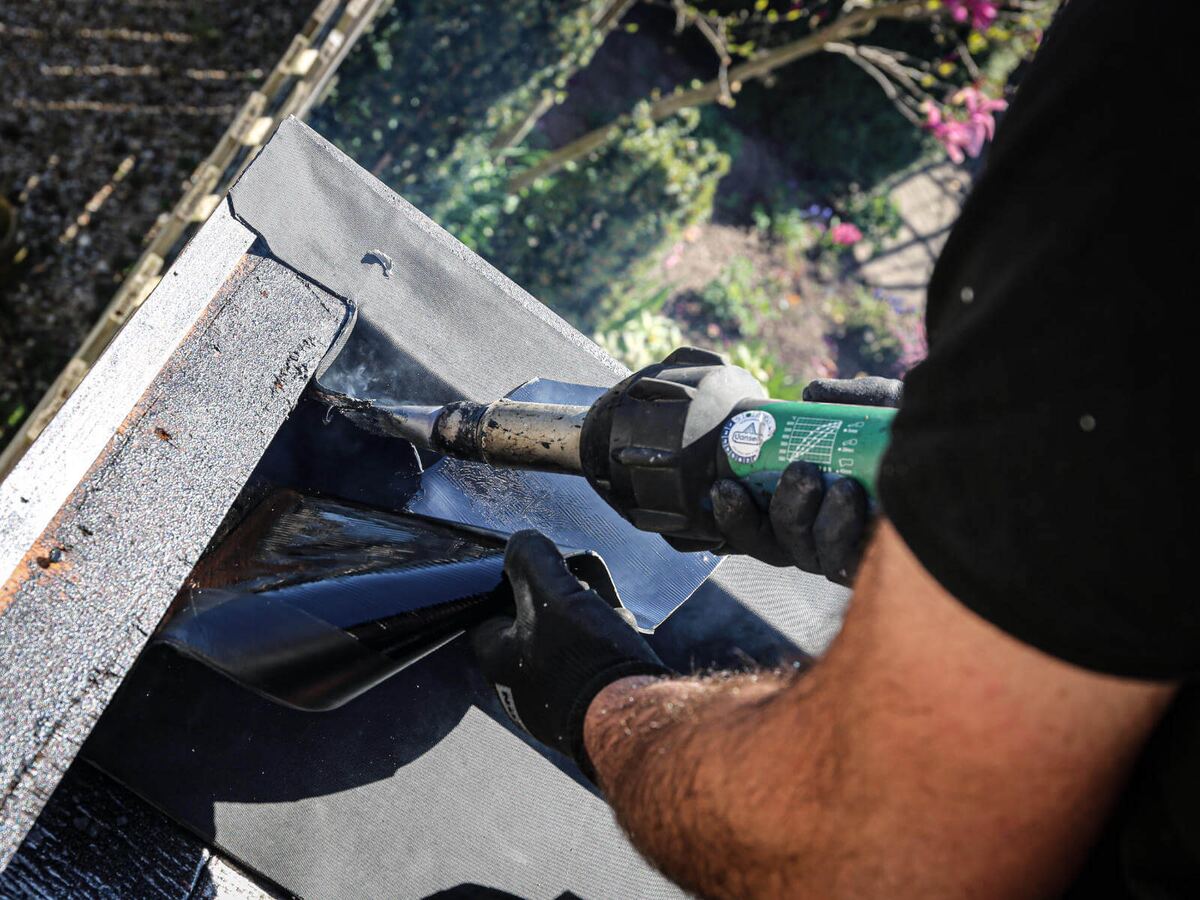 Leister Triac AT die de overlap van zelfklevende EPDM last in een dakhoek